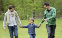 Boy walking with two men in a park
